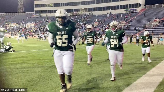 Players run on the field following gunshots during the Vigor versus Williamson football game at Ladd-Peebles Stadium in Mobile, Alabama