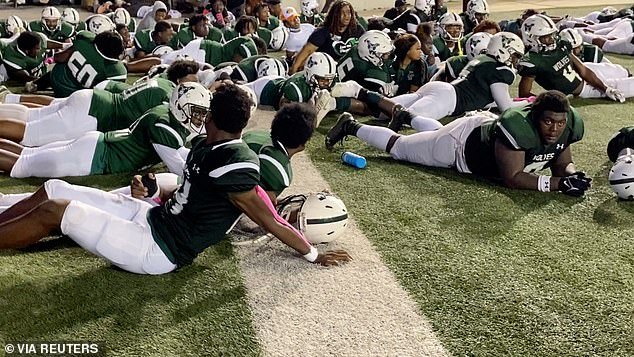 Vigor High School football players dive for cover as shots ring out during a game at Ladd-Peebles Stadium in Mobile, Alabama on Friday night