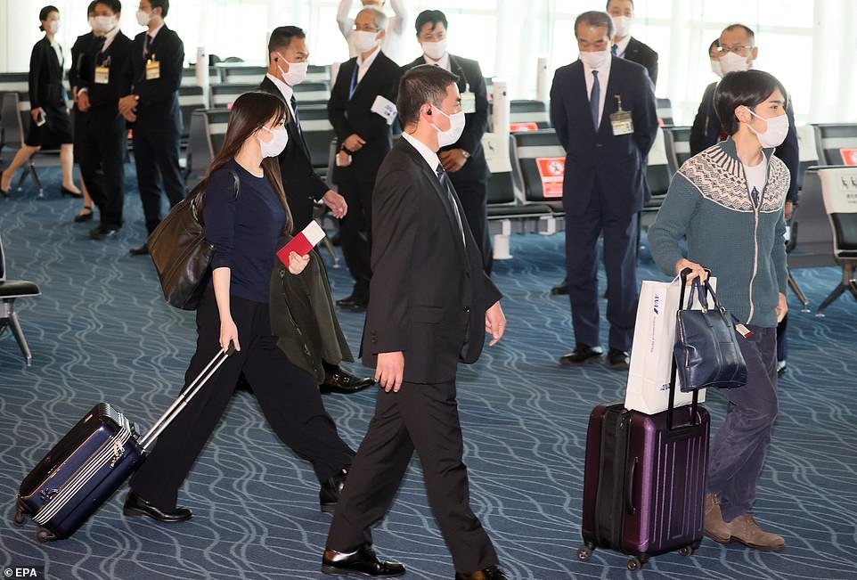 Mako wore a low-key navy blue knitted jumper with button detail and co-ordinated wide-legged trousers as she pulled along a suitcase in the same colour