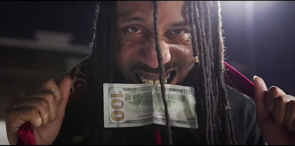 The amateur rapper is shown in a 2019 music video filmed at the back of his house where he and others in the video pose with weapons and money